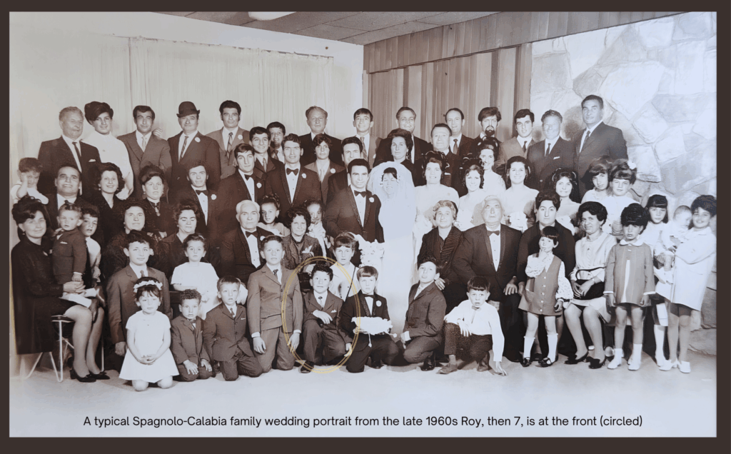 A large black-and-white Spagnolo family wedding portrait from the late 1960s in Calabria, Italy, featuring multiple generations gathered around the bride and groom. Young Roy Spagnolo, aged seven, is seated in the front row and is highlighted with a circle.